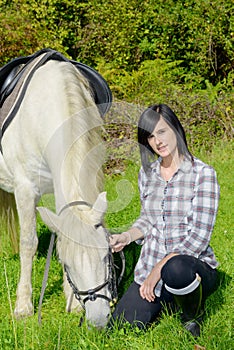 Young rider girl with her white horse