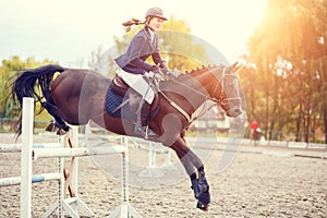 Young rider girl on horse show jumping competition