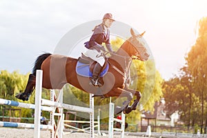 Young rider girl on horse show jumping competition