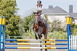 Teen girl jumping horse on her show jumping course