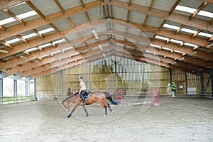 young rider on her horse doing dressage exercises in a horse farm