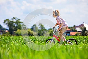 Young rider kid in sunglasses riding bicycle
