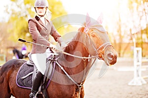 Young rider woman riding horse at the competition