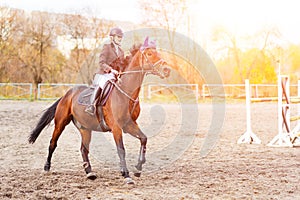 Young rider woman riding horse at the competition