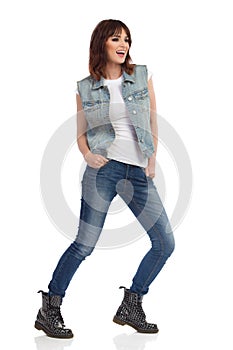 Young Rock Girl Is Standing Legs Apart, Laughing And Looking Away