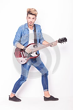 Young rocker playing his red electric guitar