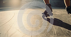 Young roller skater practicing stunt at skate park. Man legs in roller skates.