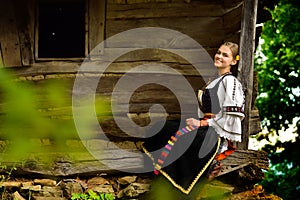 Young Romanian girl smiling on the porch of an old house