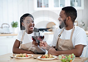 Young Romantic African American Couple Drinking Wine And Eating Spaghetti In Kitchen