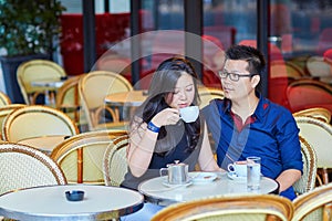 Young romantic Asian couple in Parisian cafe