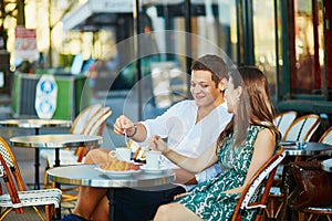 Young romantic couple in a cozy outdoor cafe in Paris, France