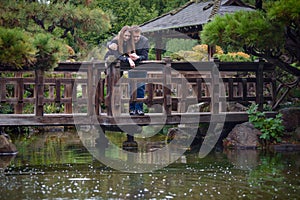 Young romantic couple hugging on the bridge looking on the water