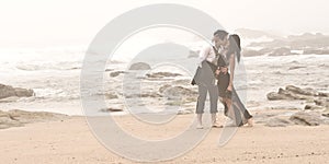 Young romantic couple kissing along beach