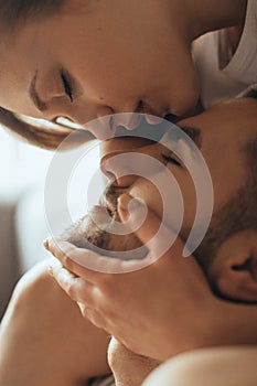 Close-up of young romantic couple is kissing and enjoying the company of each other at home