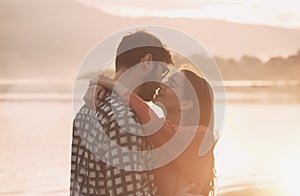 Young romantic couple kissing at sunset