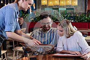 Young romantic couple ordering dinner together in a restaurant.