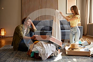 Young romantic couple preparing luggage for trip at home living room