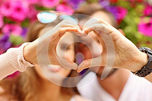 Young romantic couple showing a heart shape