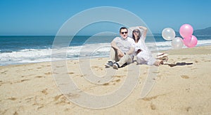 Young romantic couple sitting on the beach