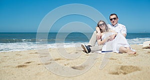 Young romantic couple sitting on the beach