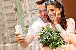 Young romantic couple using smartphone in the city photo