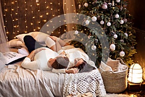 Young romantic couple waiting for new year and Christmas holiday, beautiful bokeh