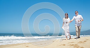 Young romantic couple walking on the beach