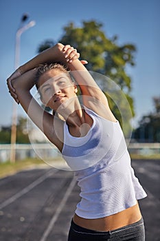 Young runner fit woman streching before exercises outdoors. Athletic female strech after workout outside. Sport and