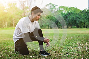 A young runner man sitting and tying the shoelace