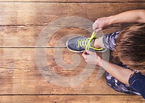 Young runner tying her shoes