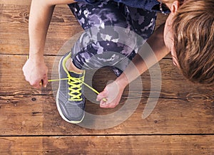 Young runner tying her shoes