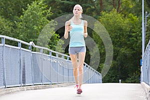 Young running woman trains her stamina outdoor