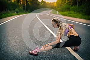 Young running woman warms up before jogging on the road. Sport.