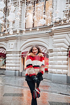 Young russian girl on the red Square through winter holiday in Moscow, stylish and beautiful posing near to Gum
