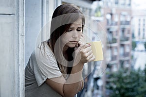 Young sad beautiful woman suffering depression looking worried and wasted on home balcony