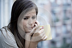 Young sad beautiful woman suffering depression looking worried and wasted on home balcony