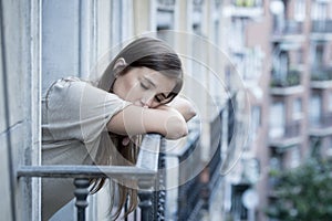 Young sad beautiful woman suffering depression looking worried and wasted on home balcony