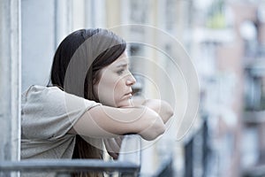 Young sad beautiful woman suffering depression looking worried and wasted on home balcony