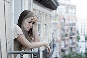 Young sad beautiful woman suffering depression looking worried and wasted on home balcony