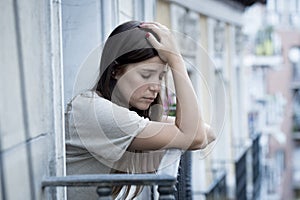 Young sad beautiful woman suffering depression looking worried and wasted on home balcony