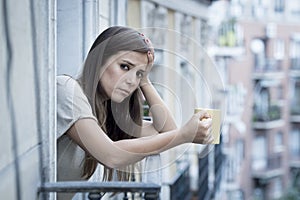 Young sad beautiful woman suffering depression looking worried and wasted on home balcony