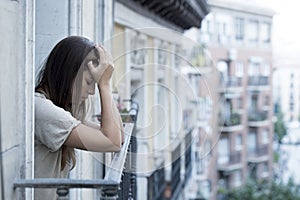 Young sad beautiful woman suffering depression looking worried and wasted on home balcony