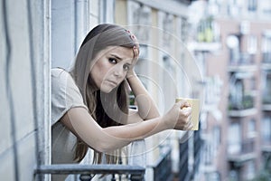 Young sad beautiful woman suffering depression looking worried and wasted on home balcony photo