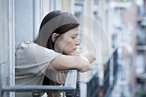 Young sad beautiful woman suffering depression looking worried and wasted on home balcony photo