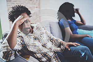 Young sad black couple.Upset man being ignored by partner at home in the living room.American african men arguing with