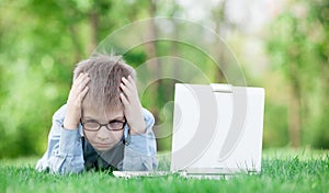 Young sad boy with laptop computer