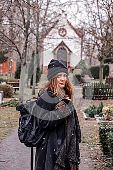 Young sad brunette woman walking alone in a cemetery