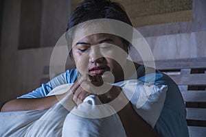 Young sad and depressed fat and chubby Asian girl feeling upset and desperate crying on bed at home victim of bullying and