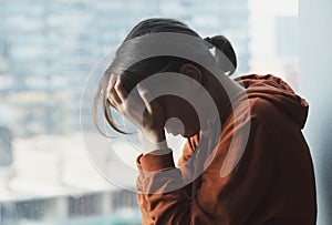 Young sad depressed frustrated woman sitting at home alone suffering and crying