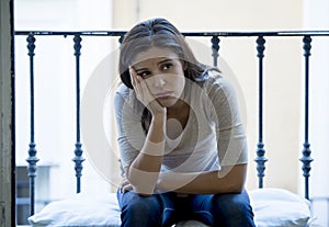 Desperate Latin woman sitting at home balcony looking destroyed and depressed suffering depression